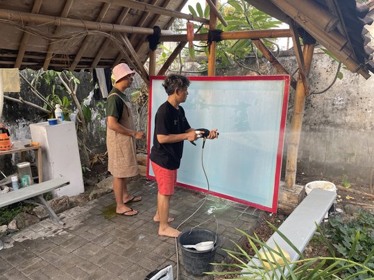 Master printers Alfin Agnuba and Rudi Hermawan cleaning screens for printing
